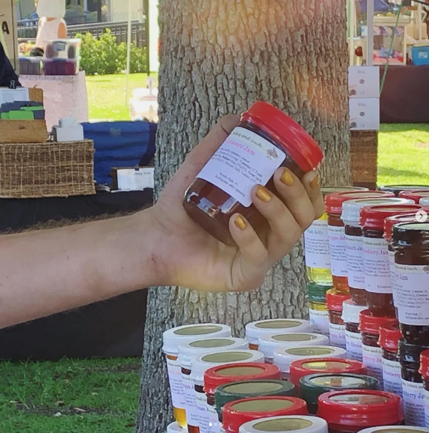 A jar of Ginger's jam held up at the farmers market