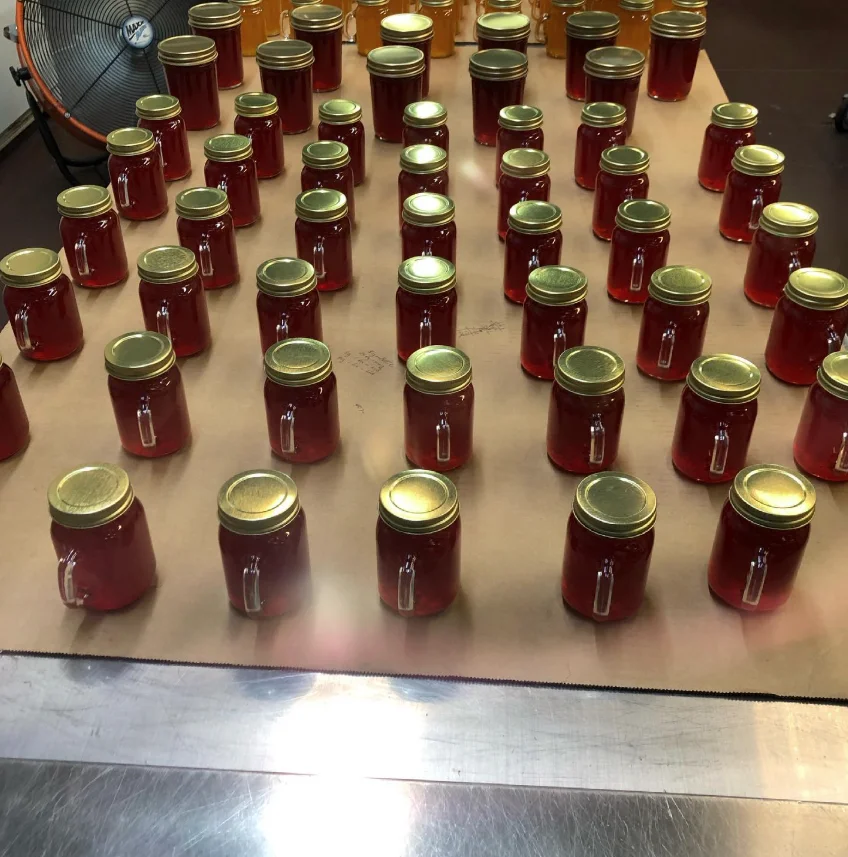 Rows of a fresh batch of ruby-red Ginger's Jam jars cooling